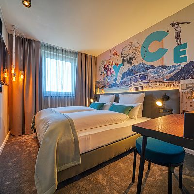 hotel room, bed, desk, chair, TV, window, colorful wall