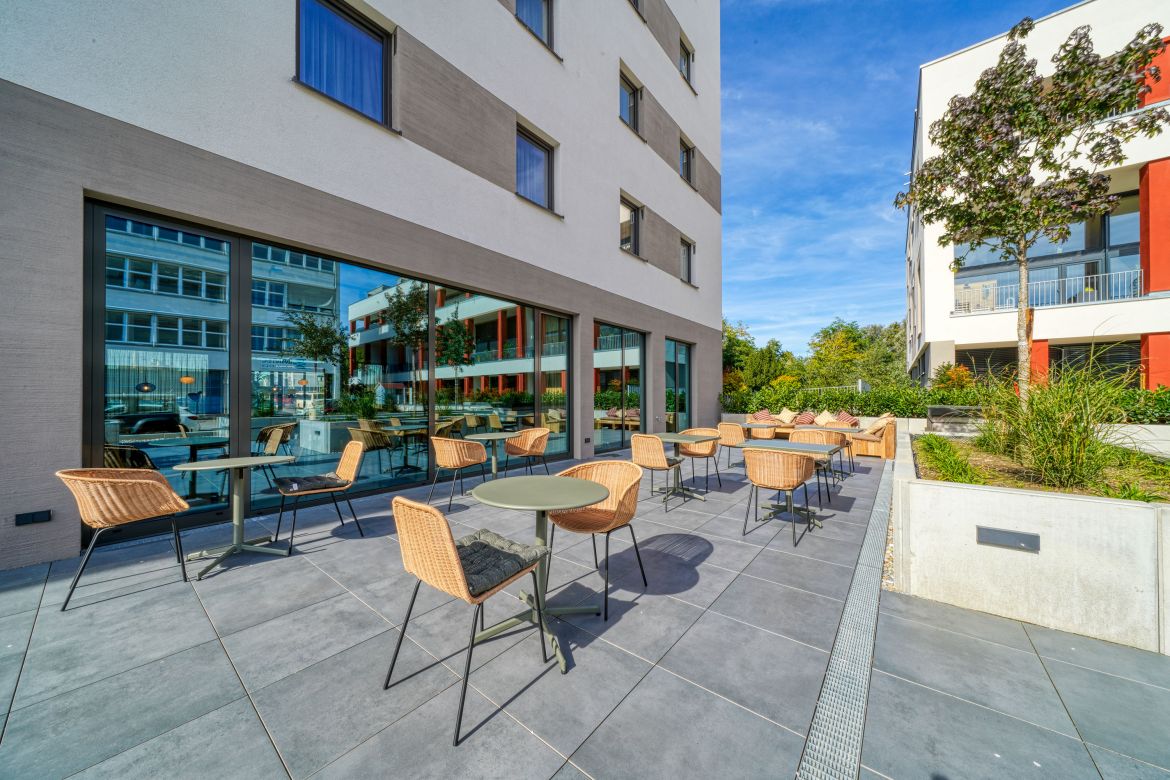 hotel building from the outside, terrace, tables and chairs